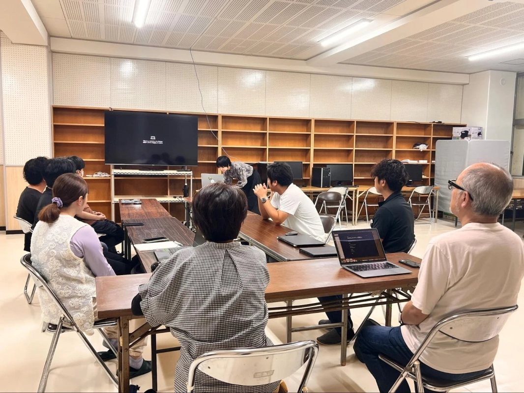 会議室で人々がPCを見ている様子