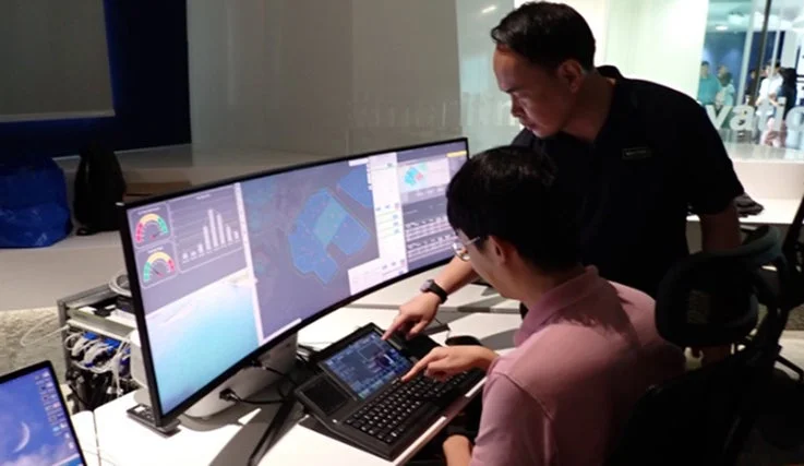 モニターを見ながら共同作業する2人の男性