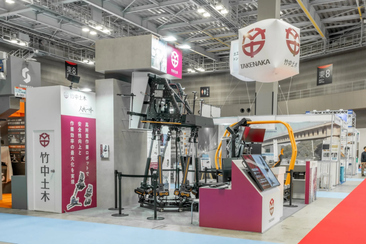 建設業の展示会ブースで高所重作業ロボットを展示している様子