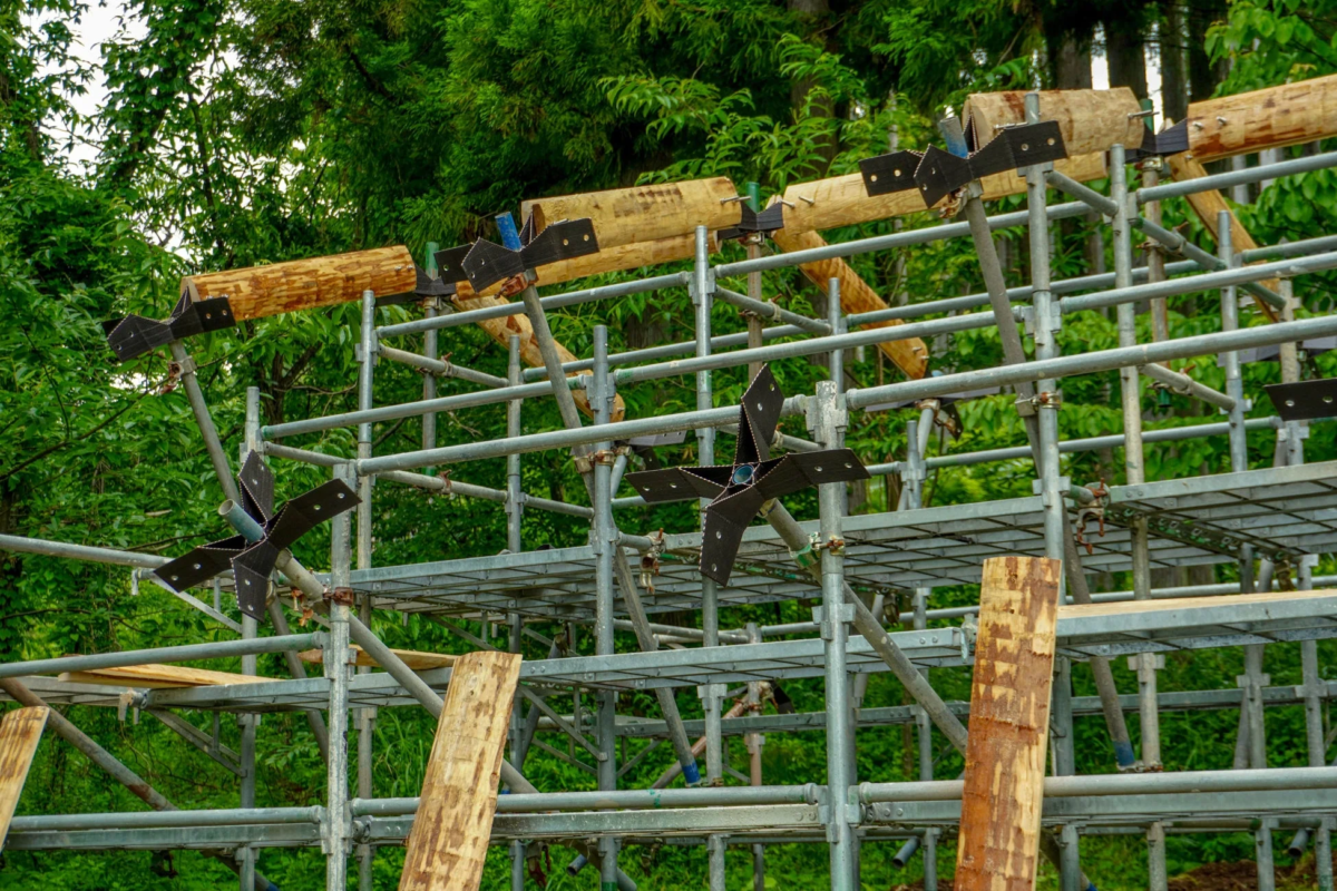建設現場での丸太と足場の様子