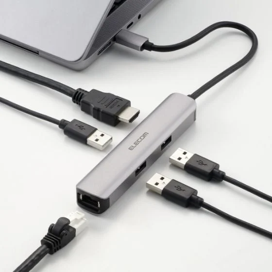 ノートパソコンに接続されたELECOM製のUSBハブで、HDMI、USB、LANケーブルなど複数のデバイスが接続されている様子