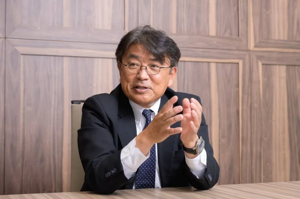 スーツ姿で話す川原秀仁氏