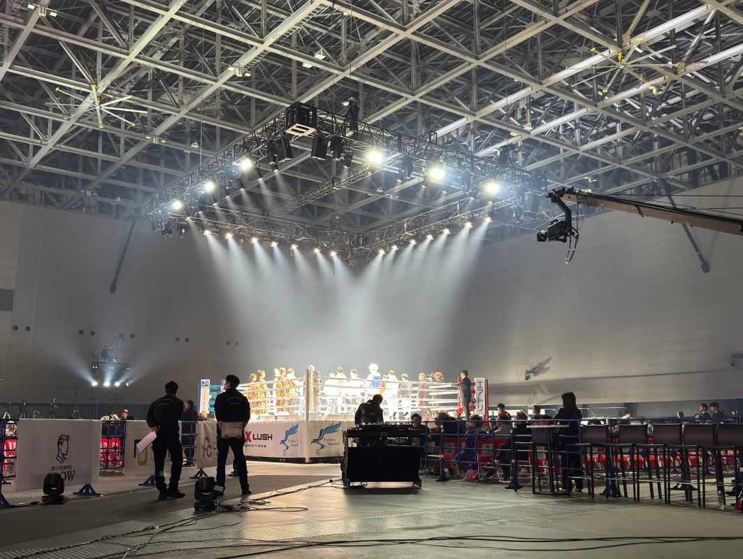 明るい照明が印象的なアリーナで開催される格闘技イベントの会場風景
