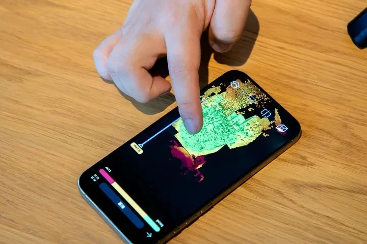 ユーザーがスマートフォンで地図のようなデータ可視化アプリを操作している様子