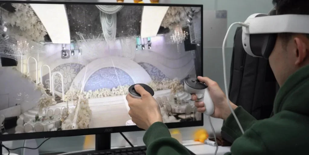 VRヘッドセットとコントローラーを操作し、モニターに映し出された豪華な仮想ウェディング会場を体験している人物