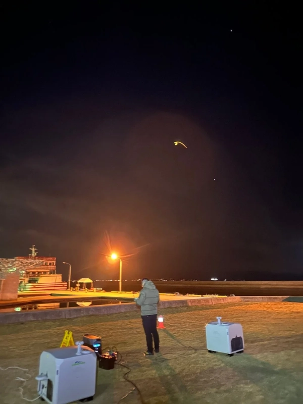 夜の港で機材を操作する人物