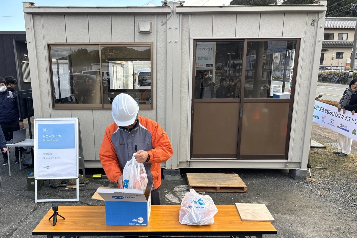 ドローンデポで荷物を準備する作業員