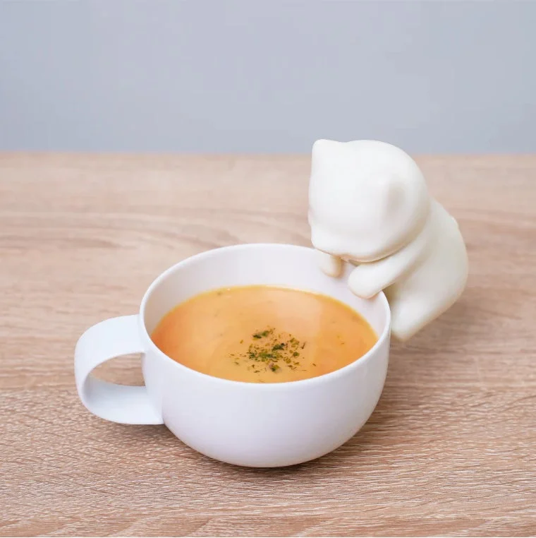 猫のフィギュアが飾られたマグカップ