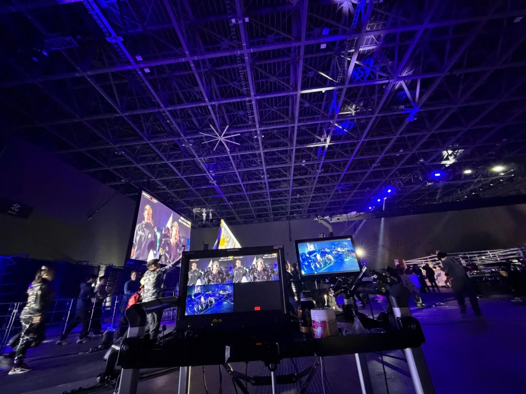 青い照明に照らされたイベント会場で、大型スクリーンに映像が映し出されている様子