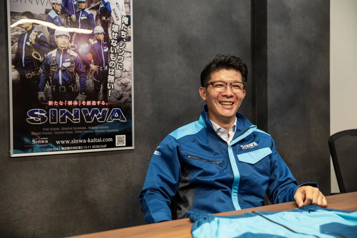 笑顔を見せる社員と企業ポスター