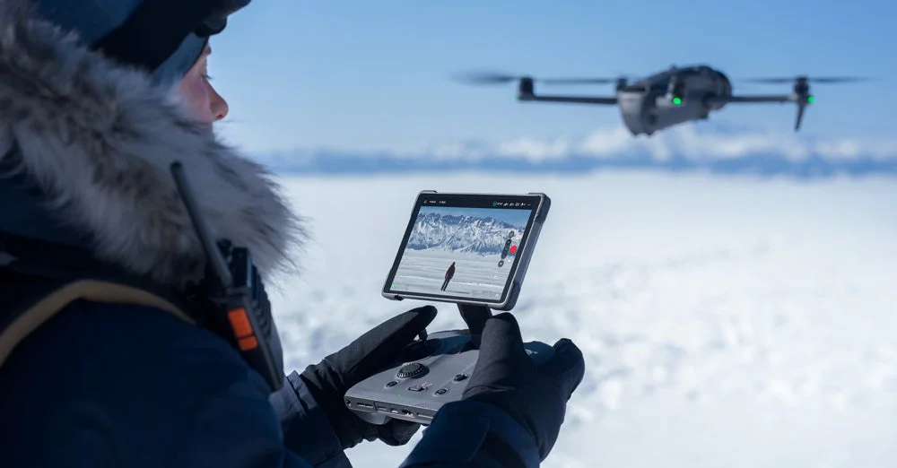 雪山でドローンを操作している様子