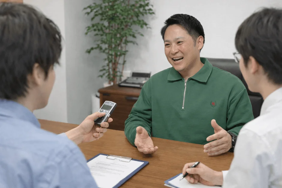 オフィスで3人の男性が打ち合わせをしている様子