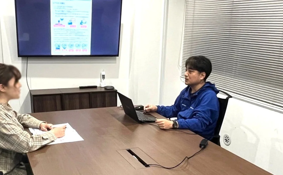 会議室で打ち合わせをする二人