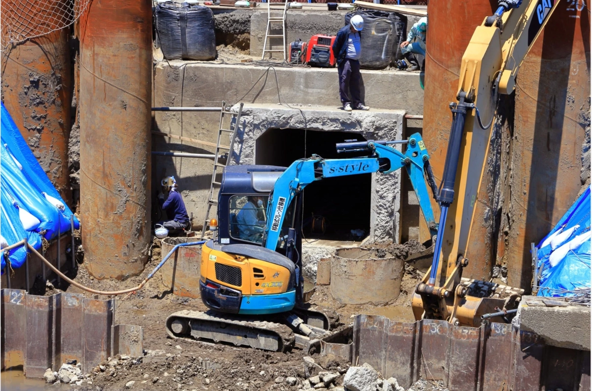 建設現場でショベルカーと作業員