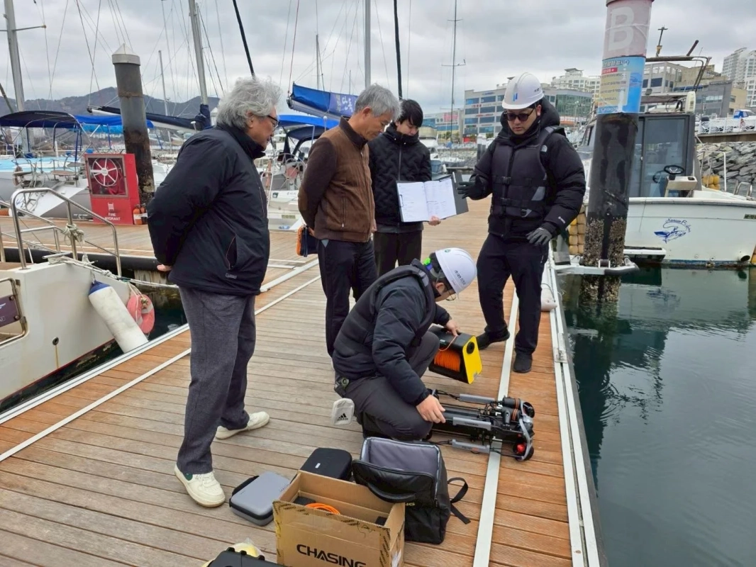 水中ドローンの準備作業を行う人々