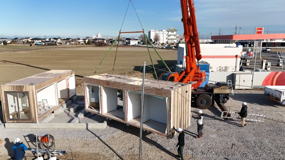 建設現場でクレーンがモジュールを設置している様子