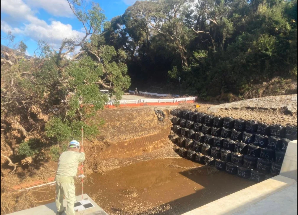 土砂崩れ現場で測量を行う作業員