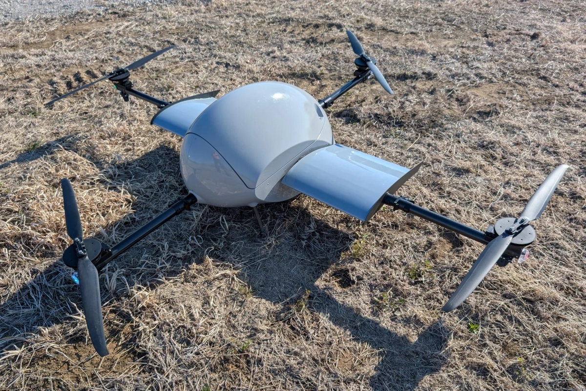 乾燥した草の地面に置かれた灰色のドローン