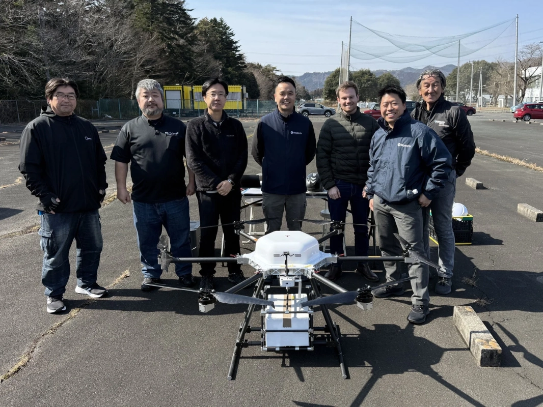 屋外でドローンを囲む人々