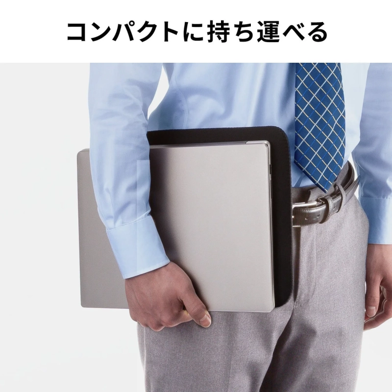 ビジネスウェアを着た男性が、薄型のノートPCをスリーブに入れて脇に抱えている様子