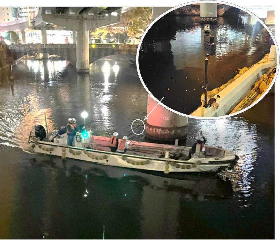 夜間の都市の川で航行する作業船