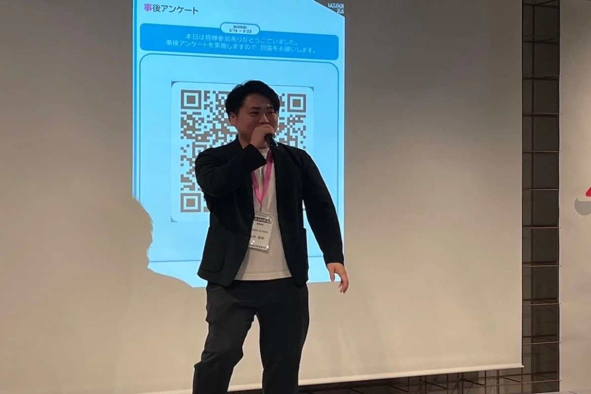 イベント会場で男性がマイクを持って講演