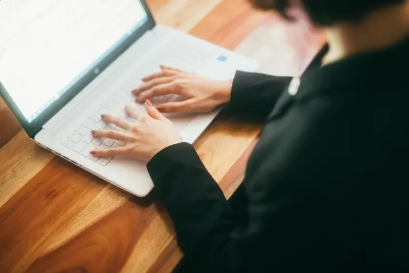 ノートパソコンでタイピングする手元