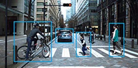 交差点の横断歩道上で、自転車に乗る人、車、走る子供、歩く大人が認識されている様子を示す画像