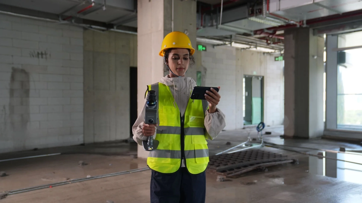 建設現場で3Dスキャナーを操作する女性