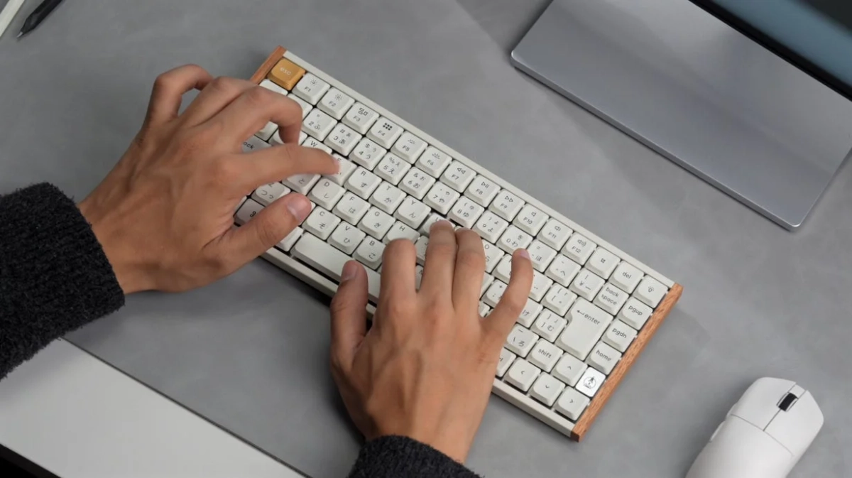 白いメカニカルキーボードを操作する人物