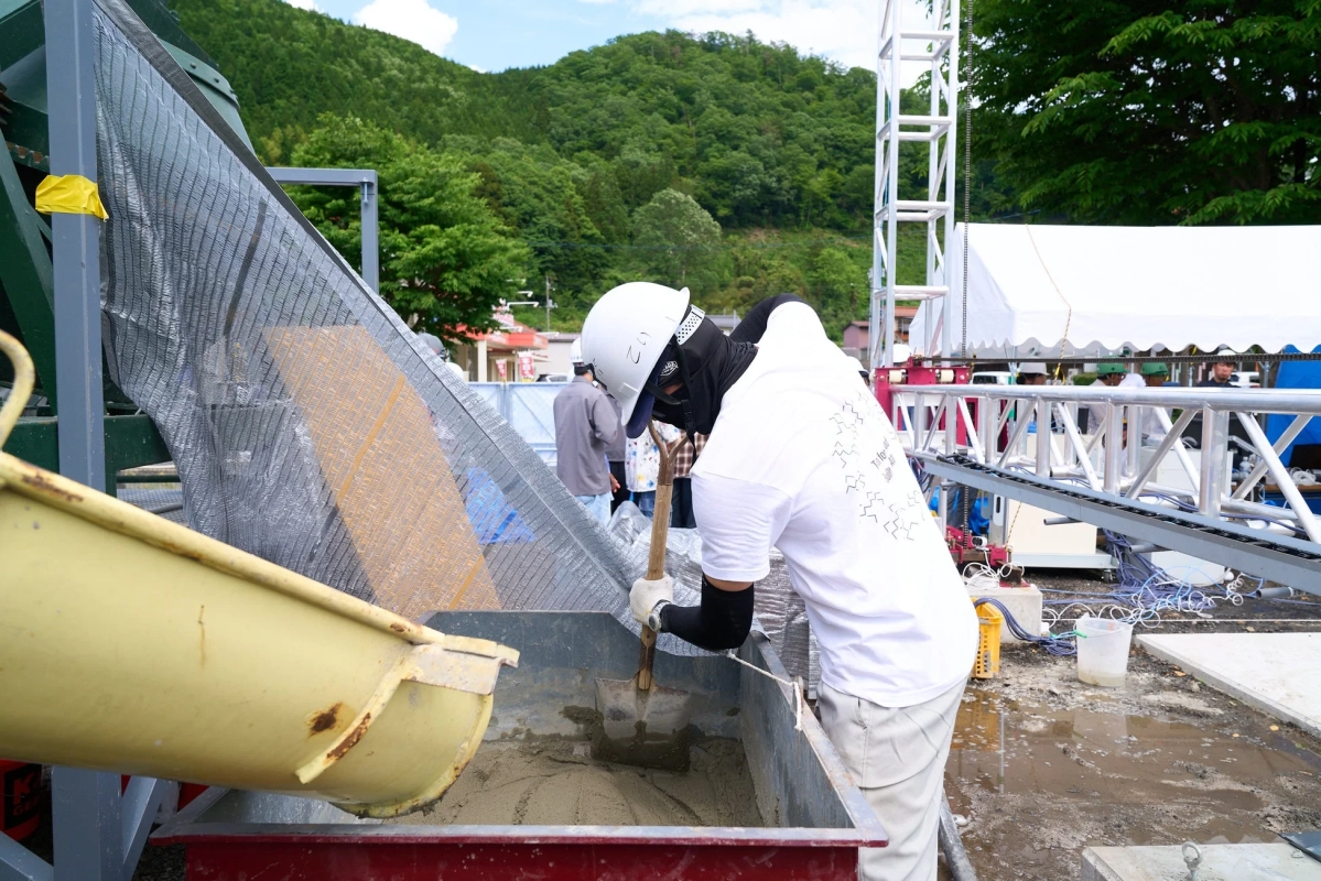 建設現場で作業員が材料を混ぜる様子