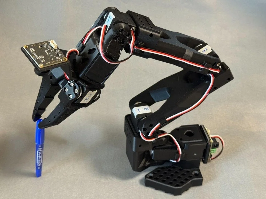 ロボットアームがペンを掴む様子