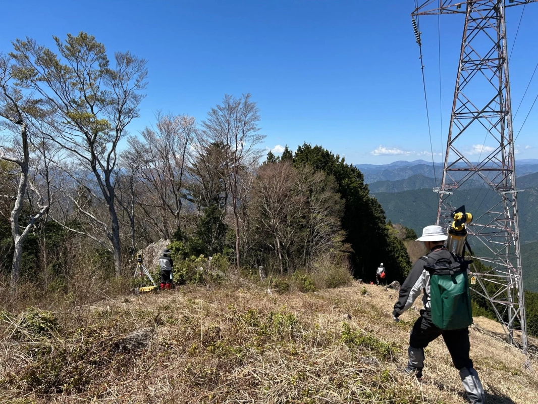山中で測量作業を行う人々