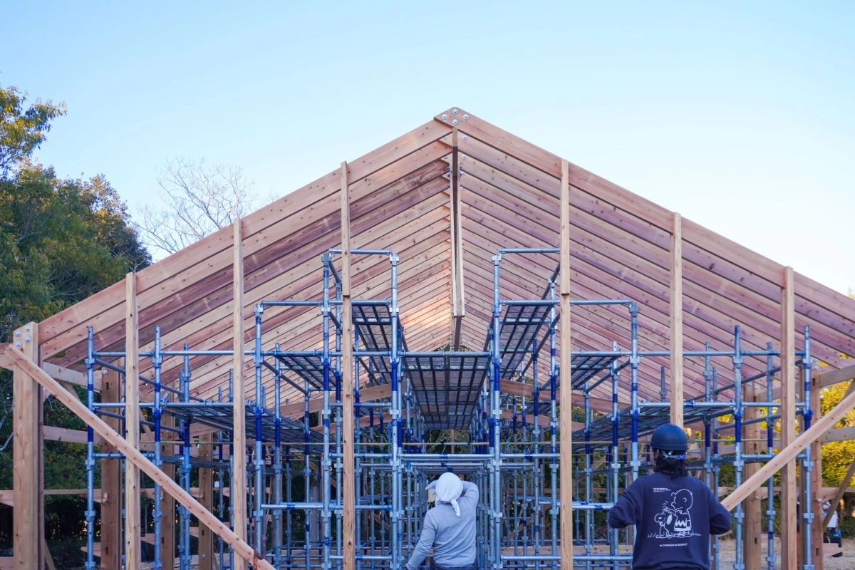 木造建築の屋根と作業員