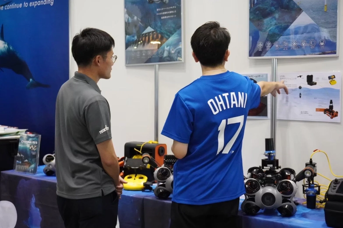展示ブースで水中ロボットを説明する様子