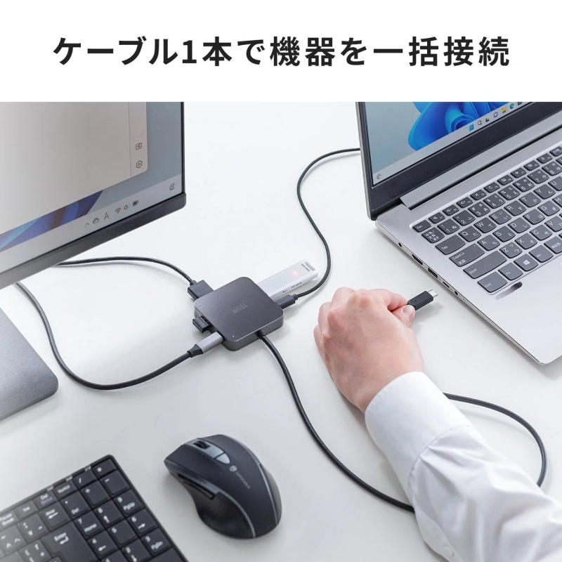 デスク上でノートパソコンにドッキングステーションを接続し、モニターやUSBデバイスなどの複数の周辺機器を一本のケーブルで一括接続している様子を捉えた画像