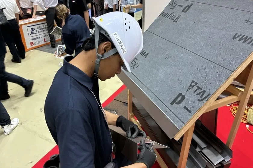 屋根の板金作業を実演するダルト技能実習生