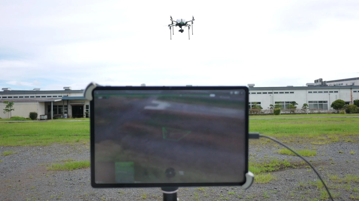ドローンが飛行し、タブレットに映像が表示されている様子