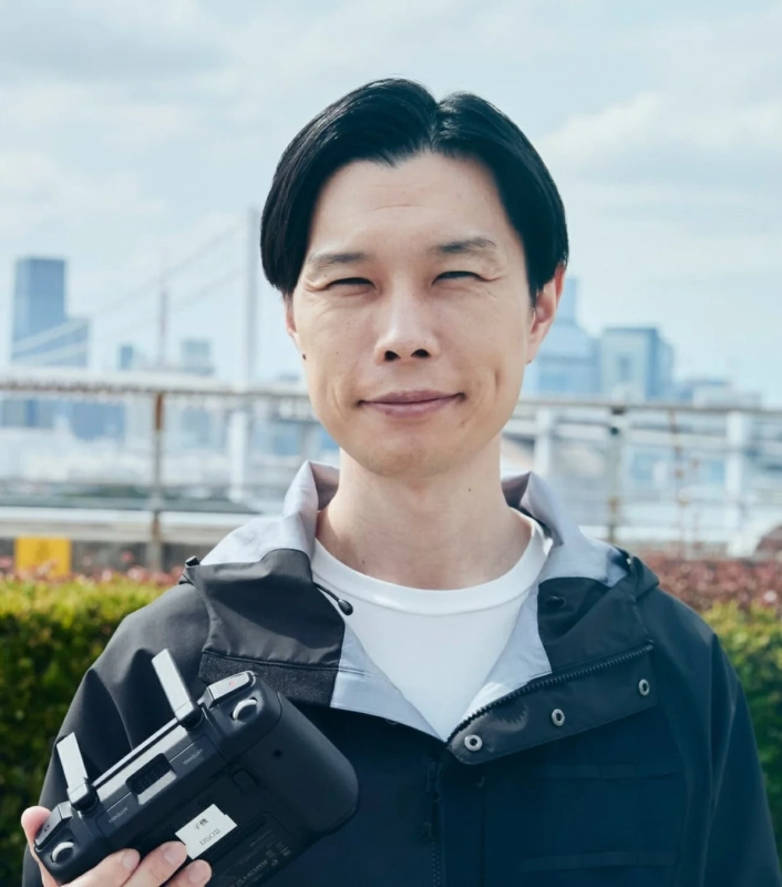 ドローンコントローラーを手に笑顔を見せる男性