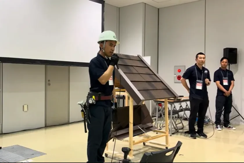 屋根工事の施工デモンストレーションを行うアジ技能実習生