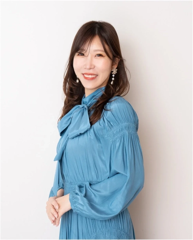 青いボウタイドレスを着た笑顔の女性のポートレート