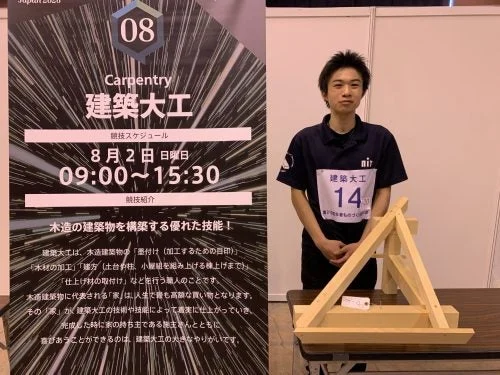 建築大工の競技会ポスターと参加者らしき若い男性