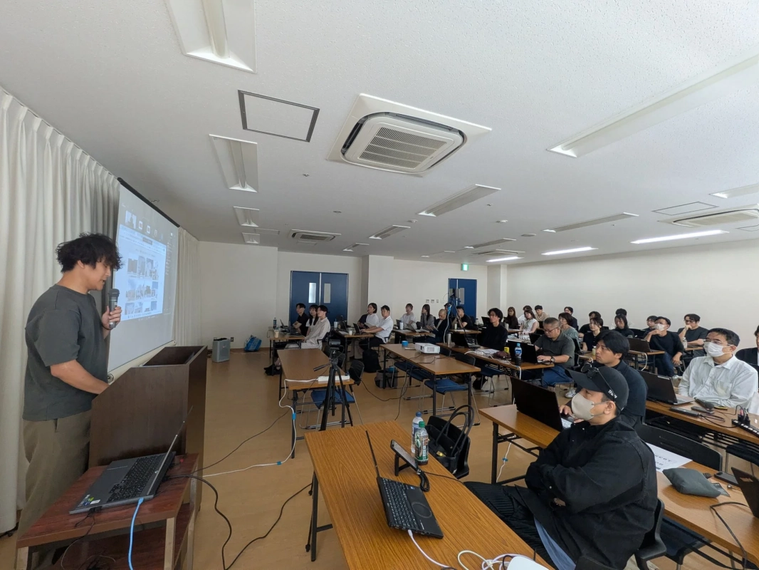 会議室でプレゼンテーションを聴講する参加者