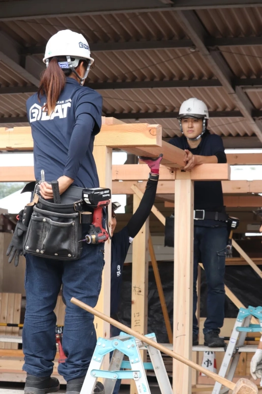 木造建築の骨組みを組み立てる作業員