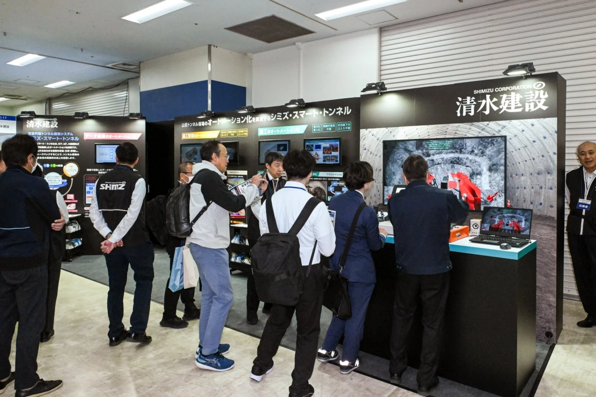 清水建設の展示ブースで次世代型トンネル構築システムについて説明を受ける人々